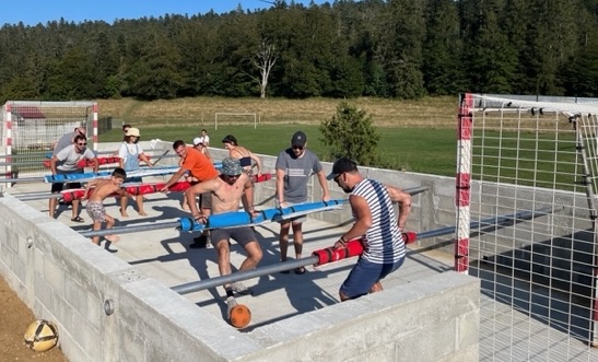 Partie de baby-foot humain, joueurs alignés sur les barres