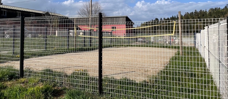 Fenced beach volleyball court with its net